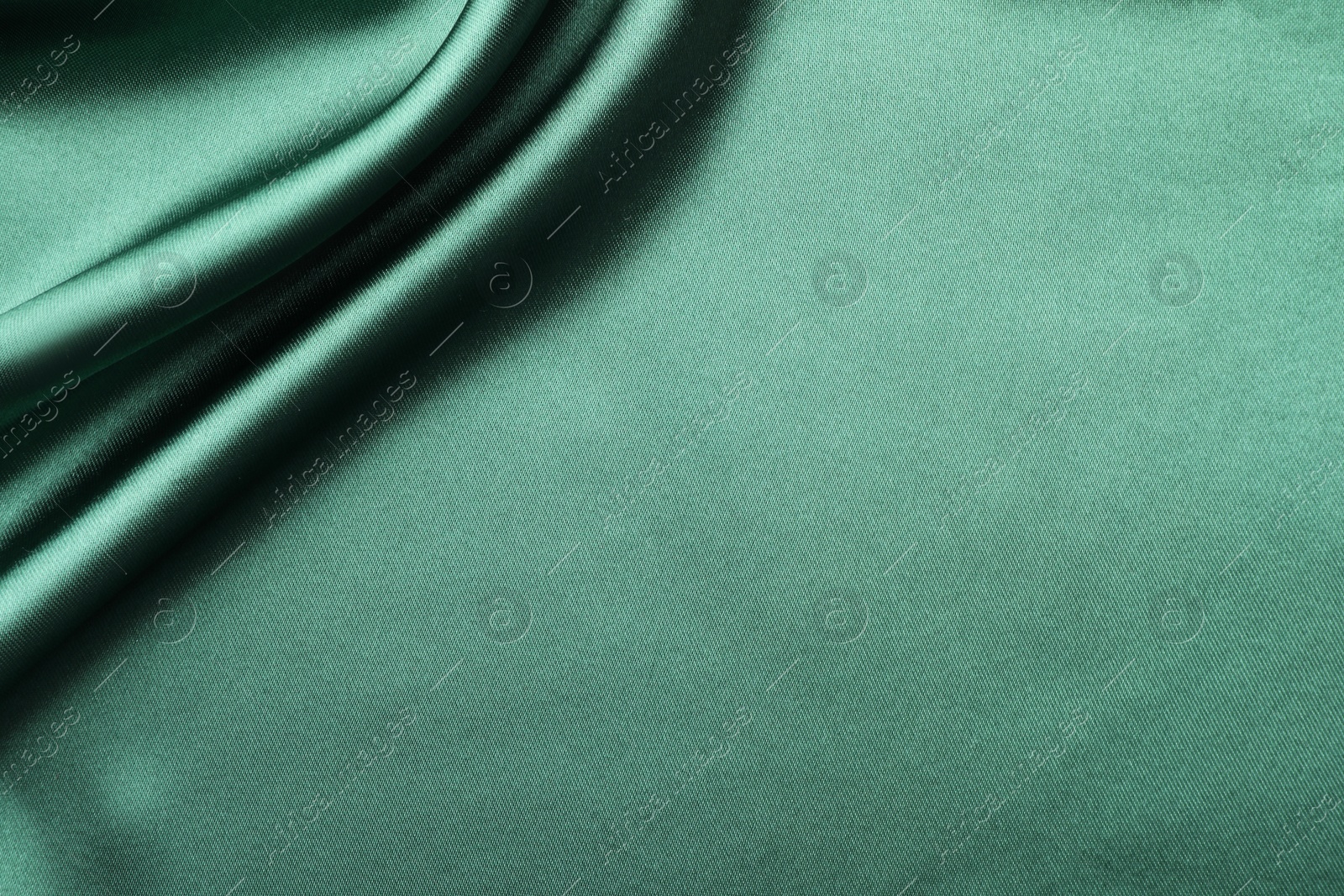 Photo of Crumpled green silk fabric as background, top view