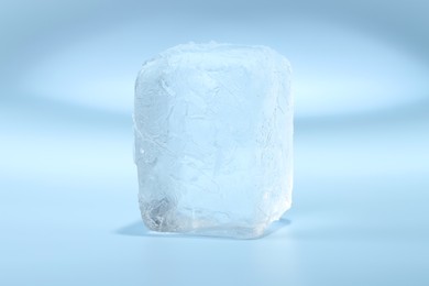 Photo of Cube of clear ice on light blue background