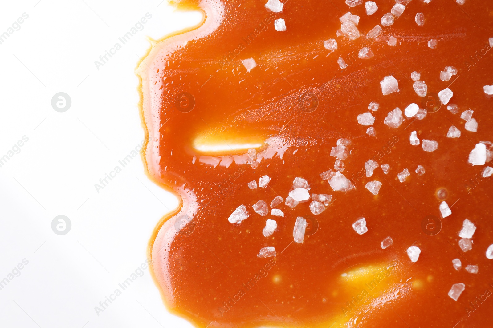 Photo of Delicious caramel sauce with sea salt on white background, top view