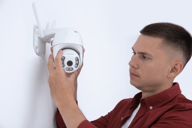 Photo of Technician installing CCTV camera on wall indoors