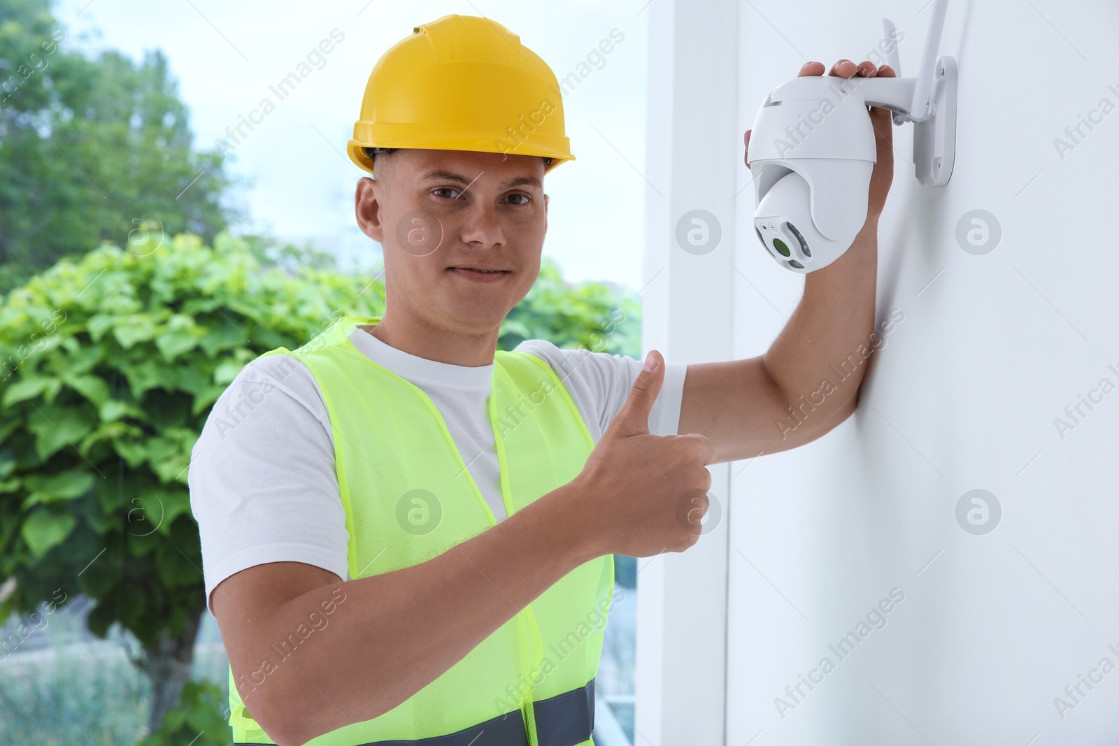 Photo of Technician showing thumb up near CCTV camera