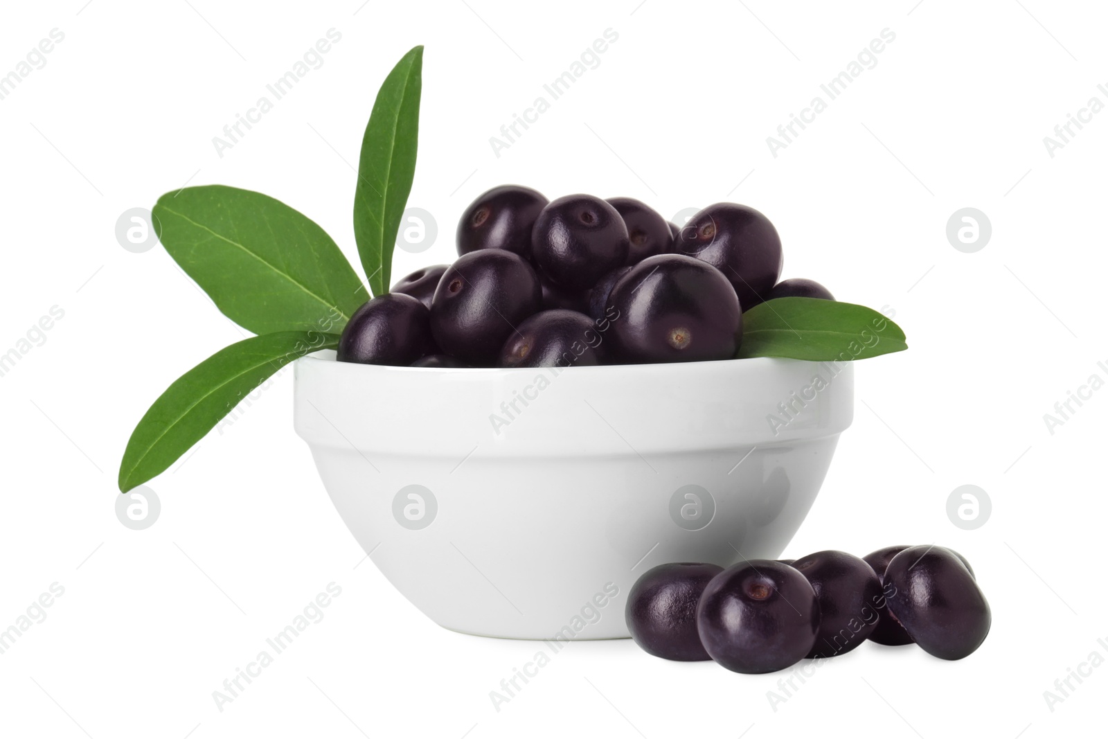 Photo of Fresh ripe acai berries in bowl and green leaves isolated on white