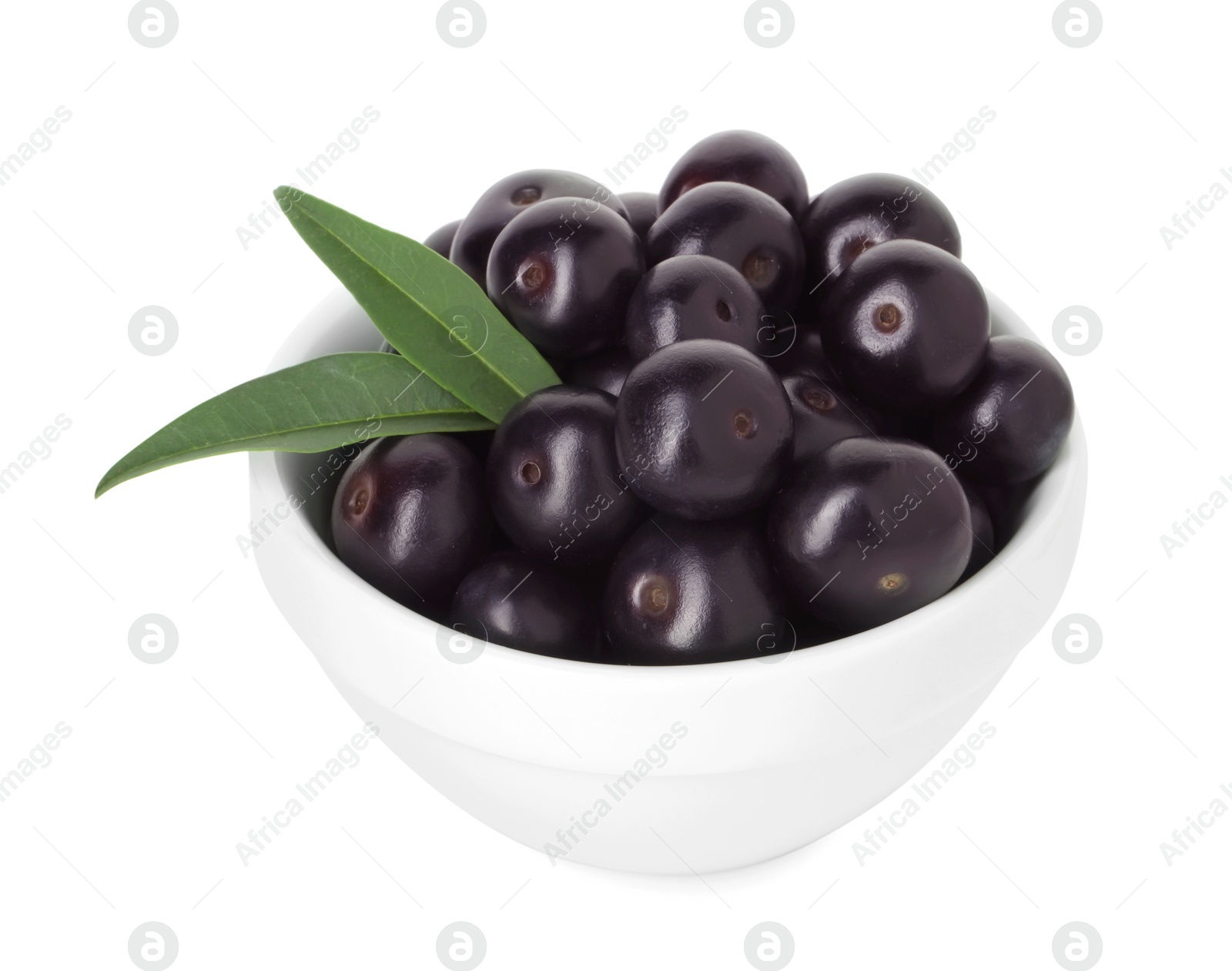 Photo of Fresh ripe acai berries in bowl and green leaves isolated on white