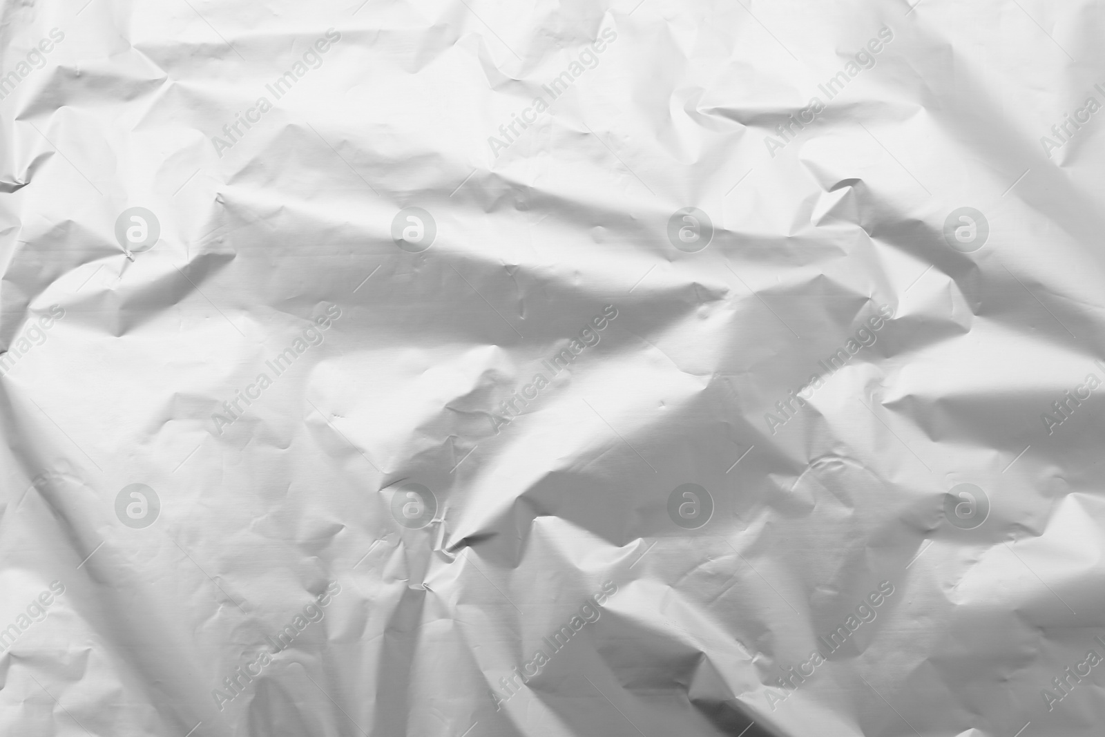 Photo of Crumpled silver foil as background, top view