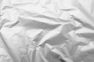 Crumpled silver foil as background, top view