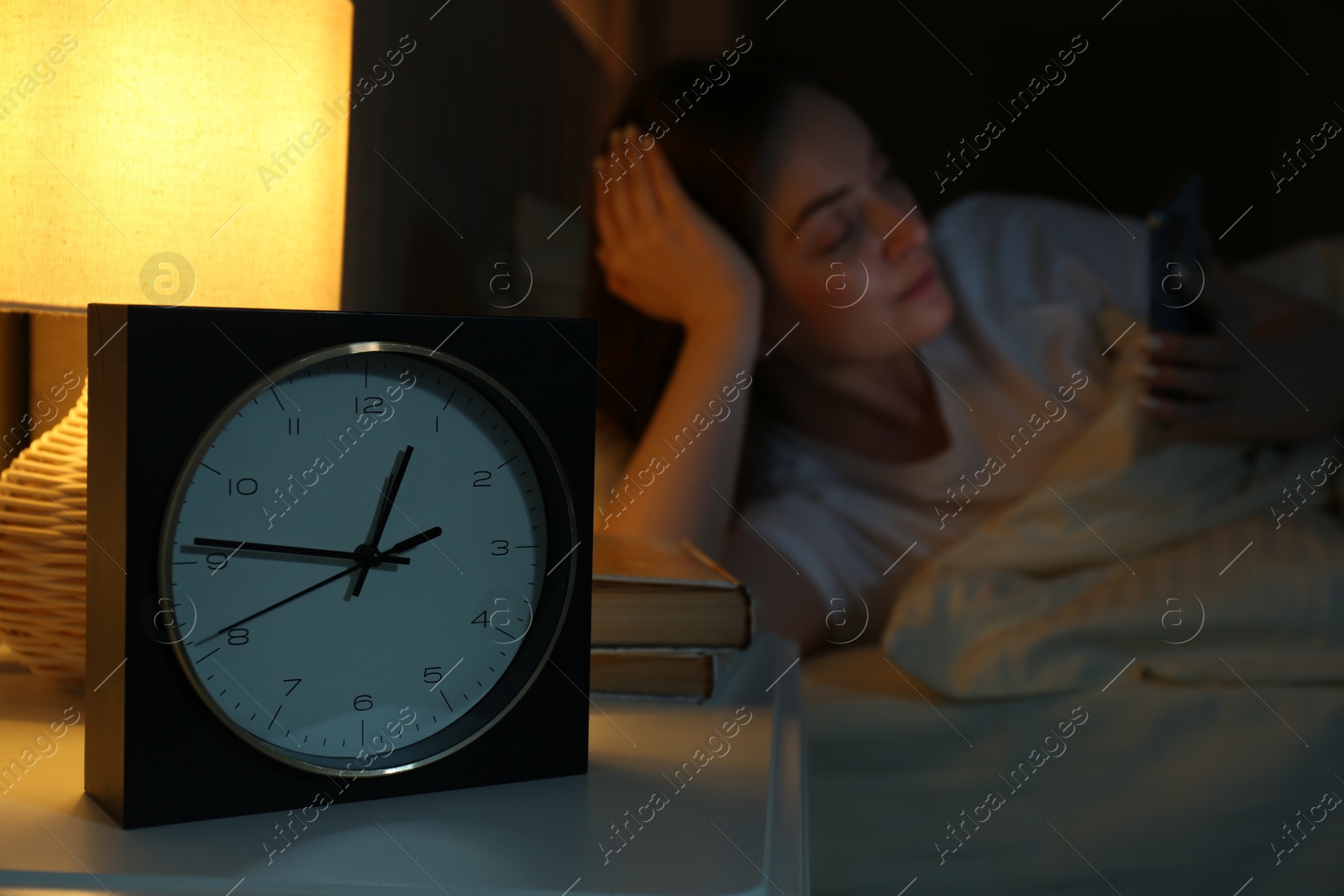 Photo of Woman using smartphone on bed at night, selective focus. Internet addiction