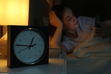 Woman using smartphone on bed at night, selective focus. Internet addiction