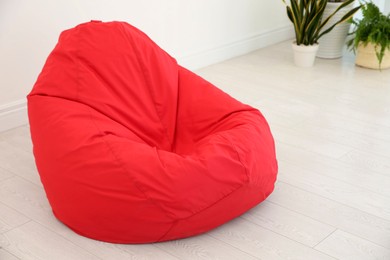 Photo of Red bean bag chair near light wall in room