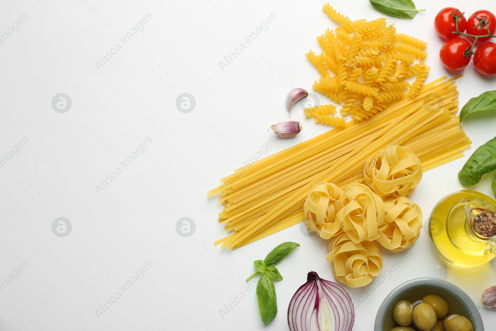 Photo of Different types of pasta, spices and products on white background, top view. Space for text