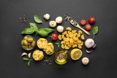 Photo of Different types of pasta, spices and products on black background, flat lay