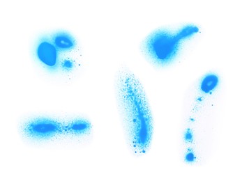 Photo of Abstract spots drawn by blue spray paint isolated on white, top view