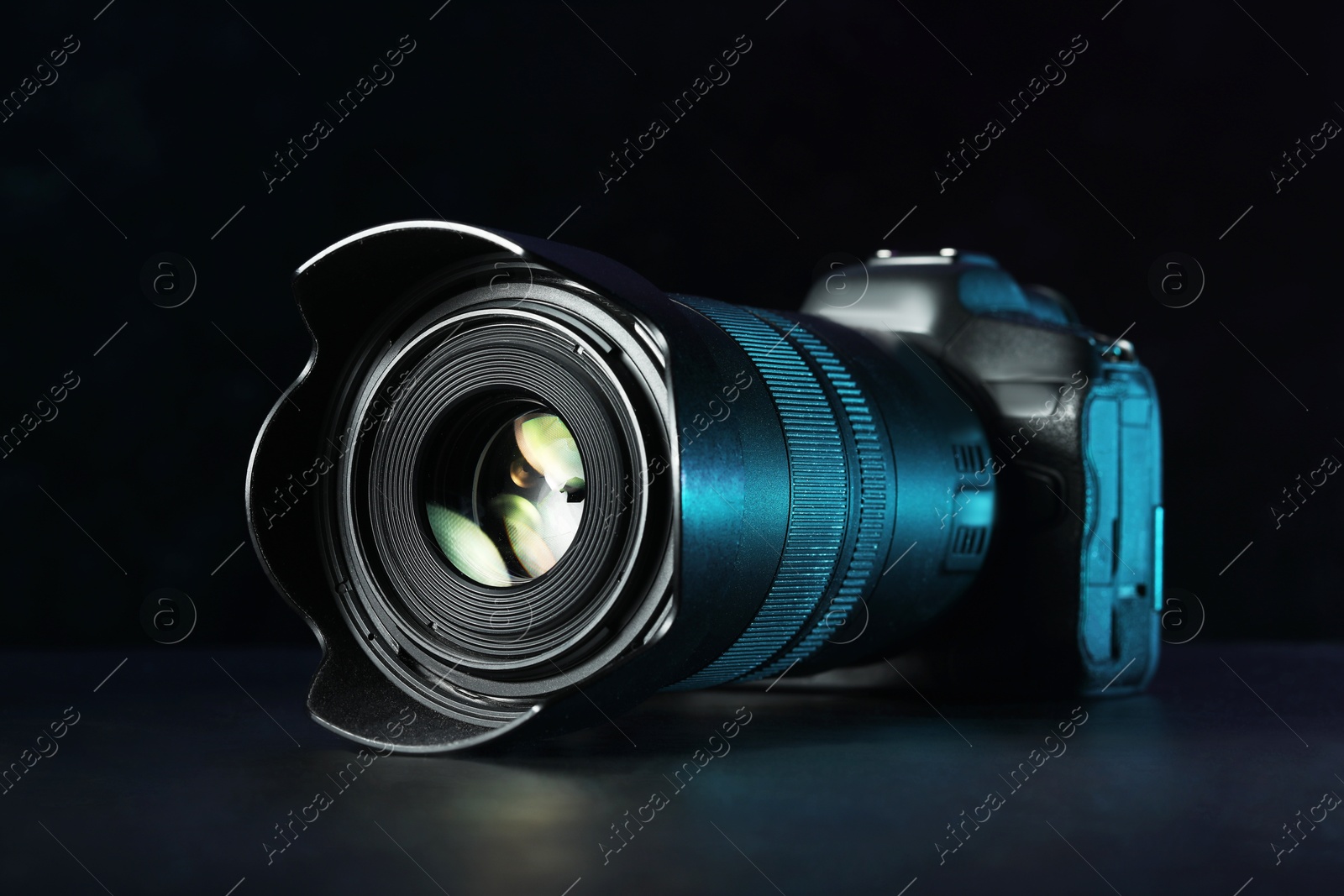 Photo of Modern photo camera on black table. Photographer's equipment