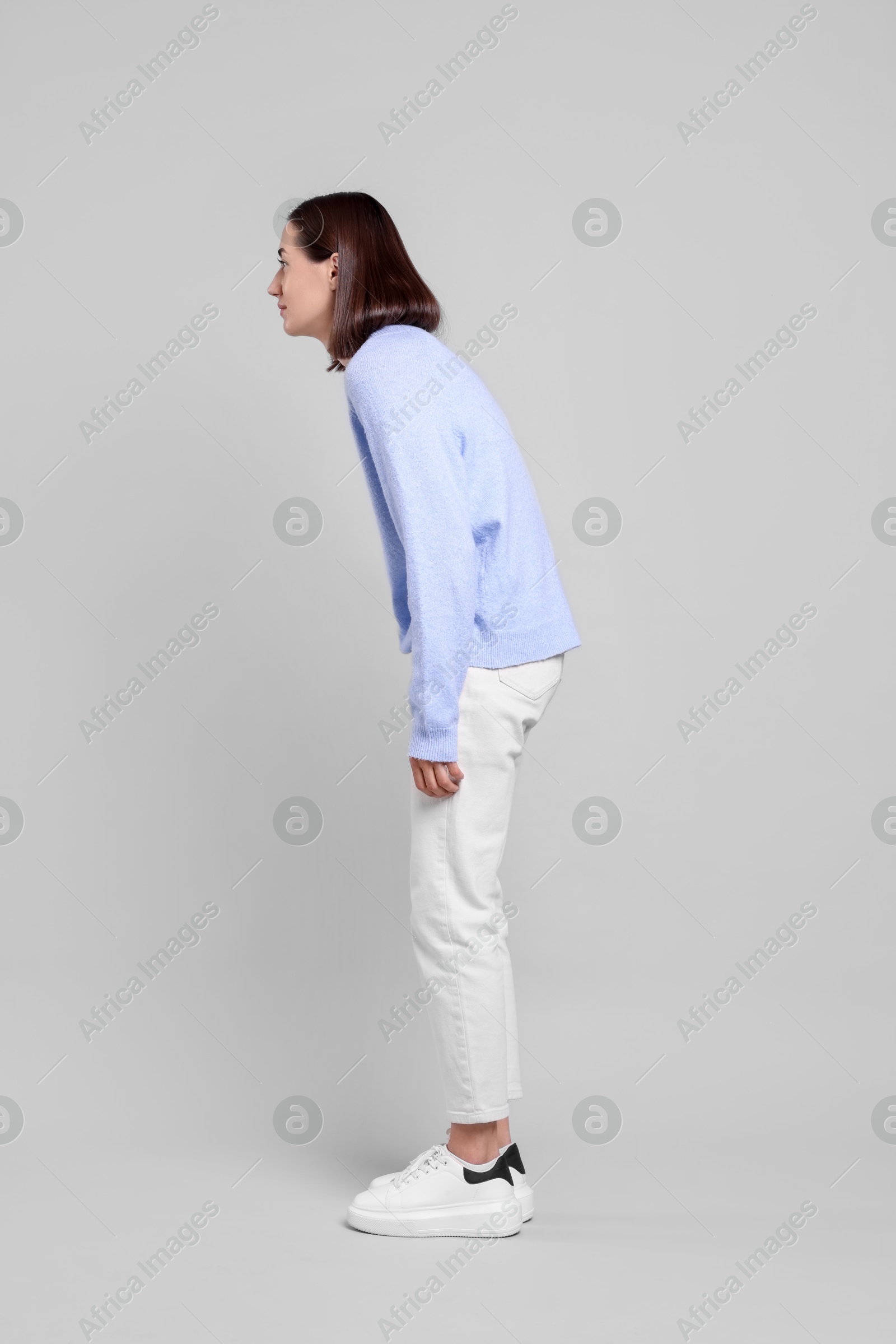 Photo of Woman with poor posture on gray background