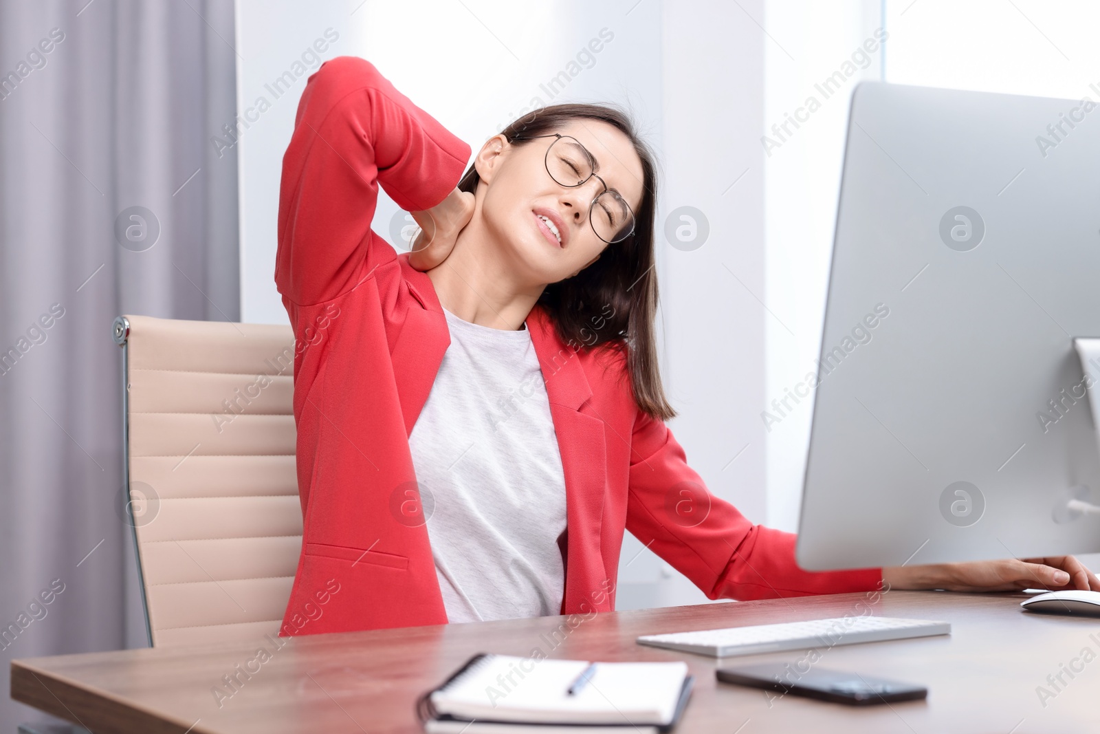 Photo of Woman suffering from neck pain in office. Symptom of poor posture