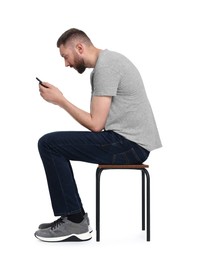 Man with poor posture sitting on chair and using smartphone against white background