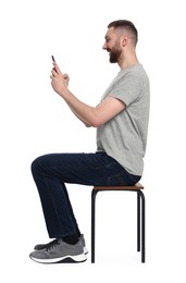 Man with good posture sitting on chair and using smartphone against white background