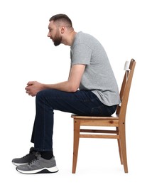 Man with poor posture sitting on chair against white background