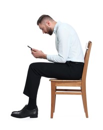 Photo of Man with poor posture sitting on chair and using smartphone against white background