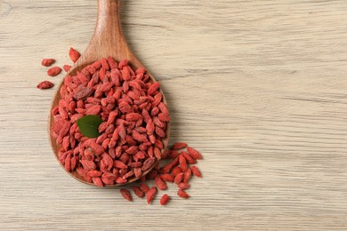 Photo of Dried goji berries on wooden table, top view. Space for text