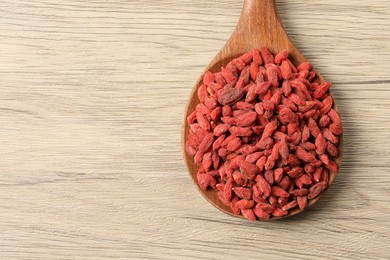 Photo of Dried goji berries on wooden table, top view. Space for text