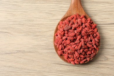 Dried goji berries on wooden table, top view. Space for text