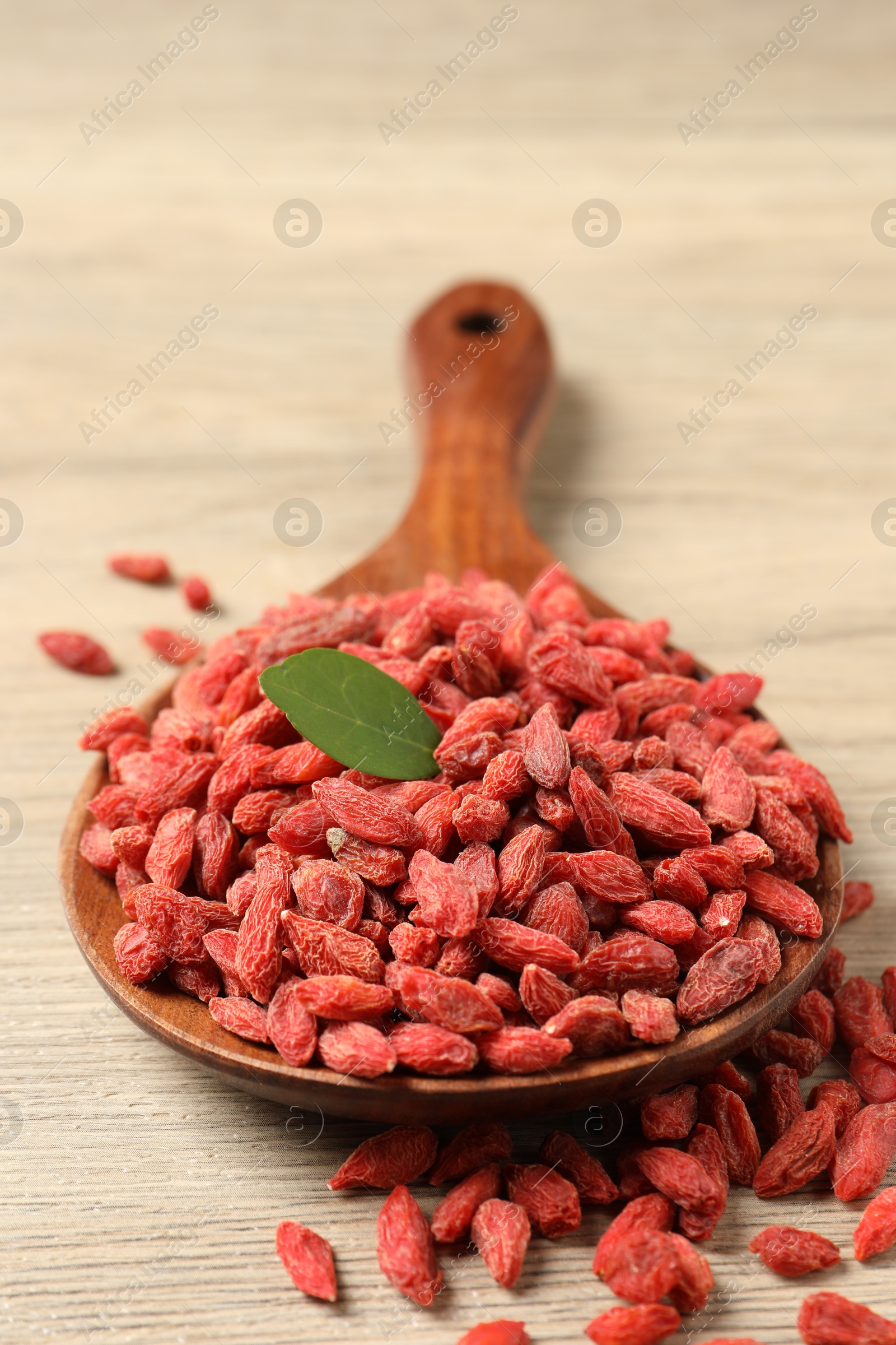 Photo of Dried goji berries on wooden table, closeup