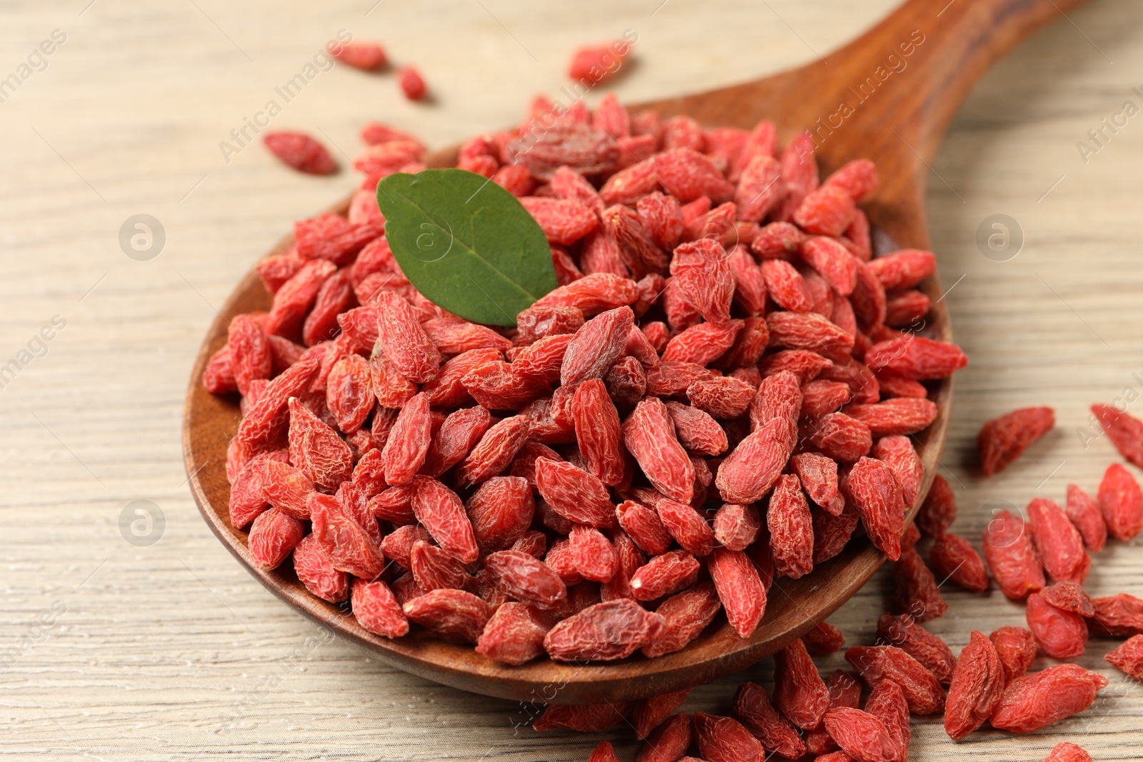 Photo of Dried goji berries on wooden table, closeup