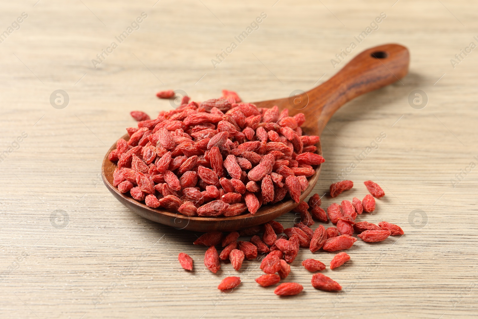 Photo of Dried goji berries on wooden table, closeup