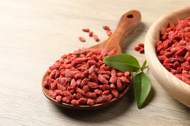 Photo of Dried goji berries on wooden table, closeup