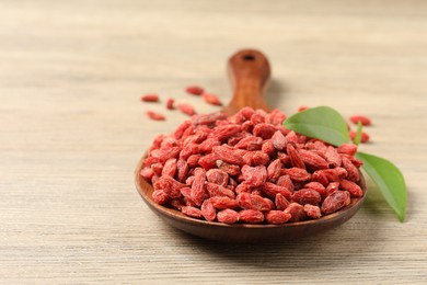 Photo of Dried goji berries on wooden table, closeup