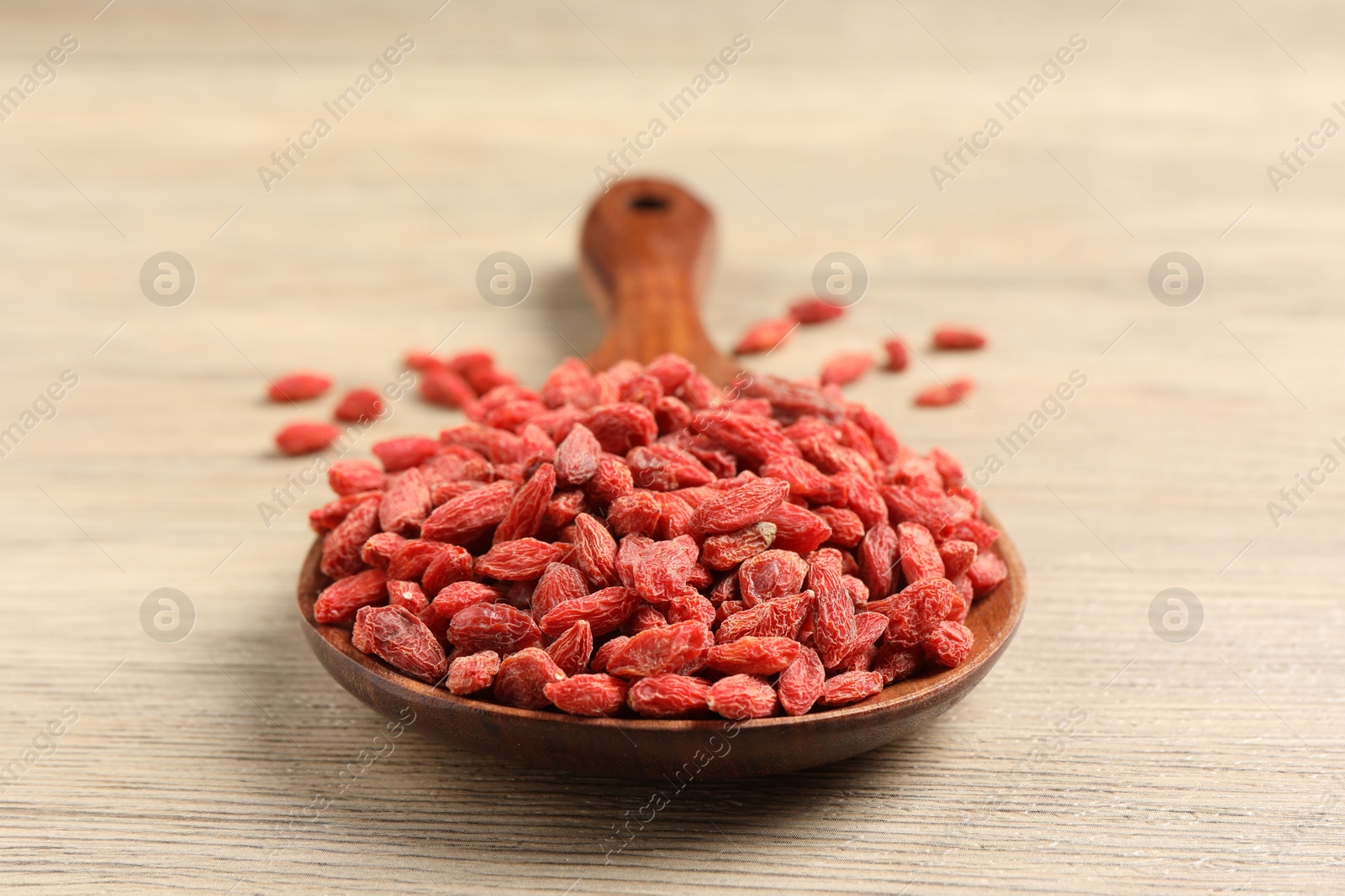 Photo of Dried goji berries on wooden table, closeup