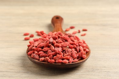 Photo of Dried goji berries on wooden table, closeup