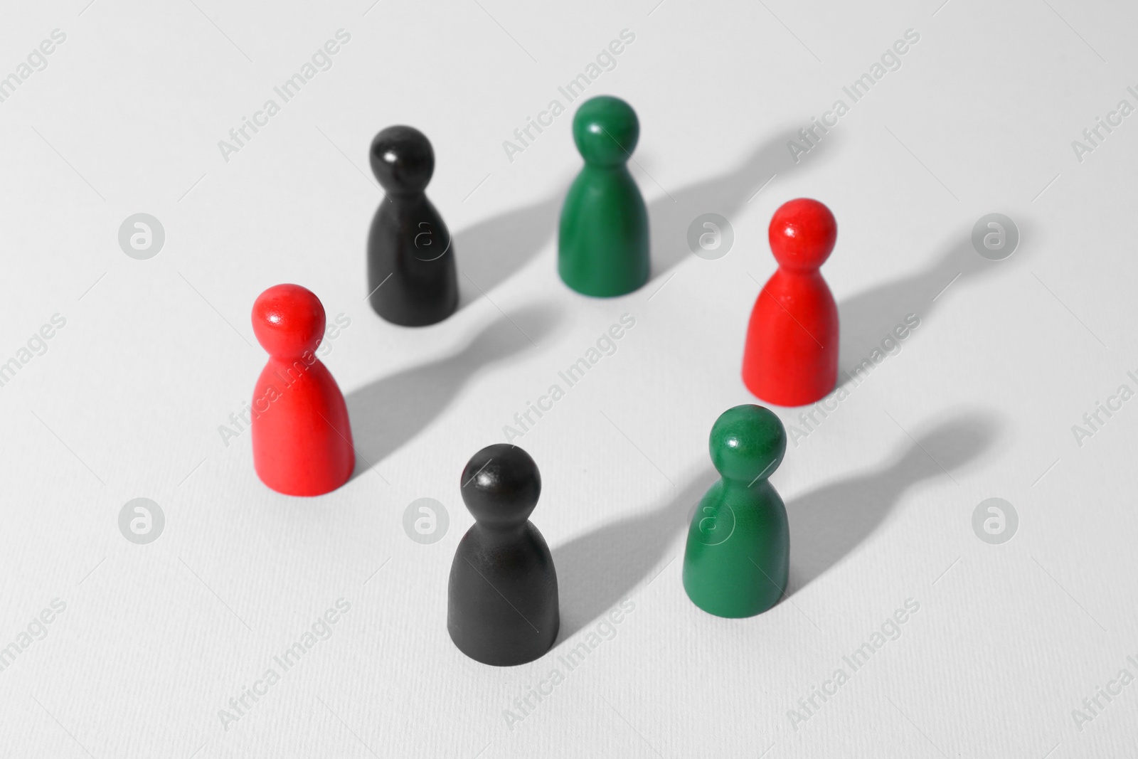 Photo of Equality concept. Different game pieces on light background