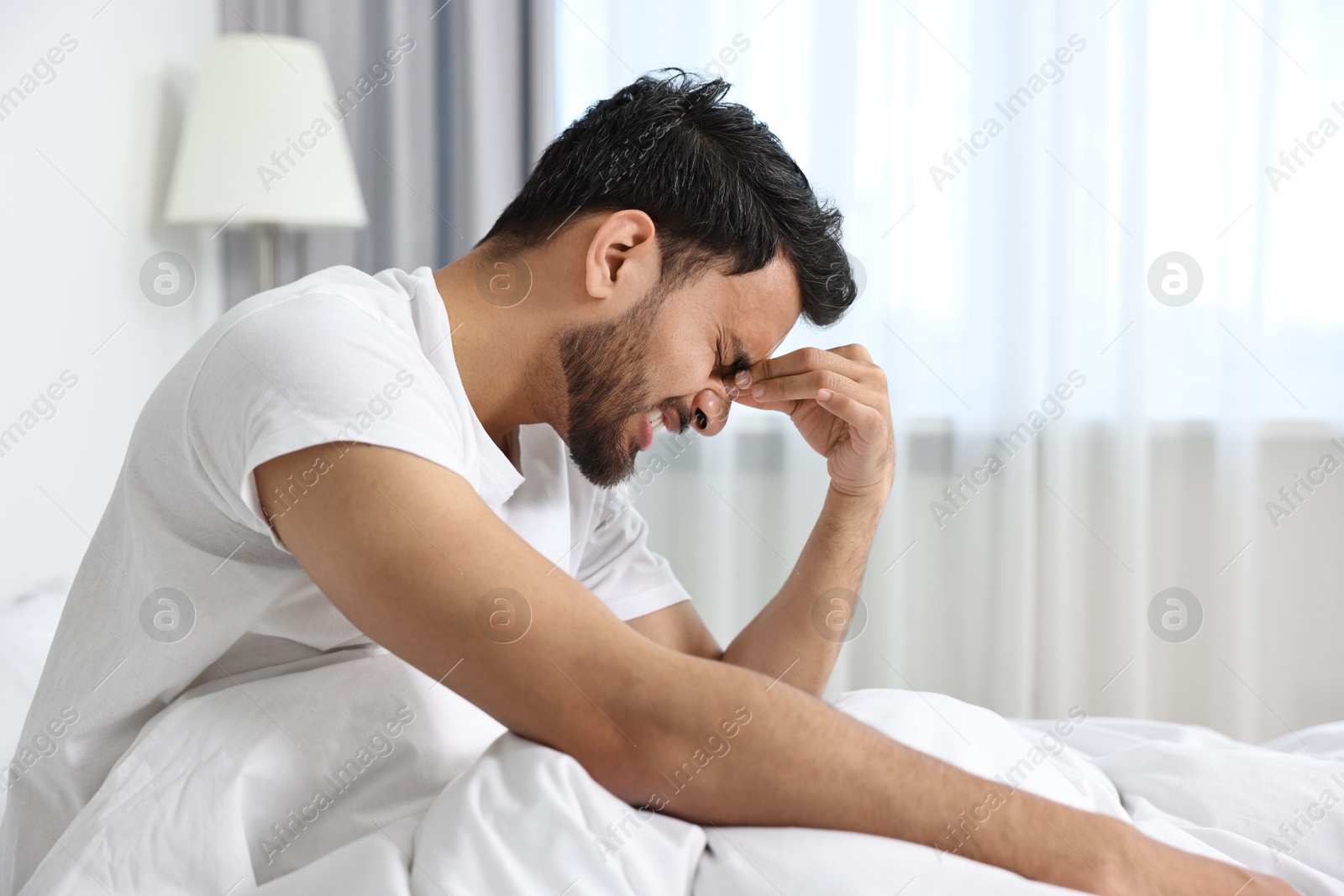 Photo of Morning of man suffering from headache in bed