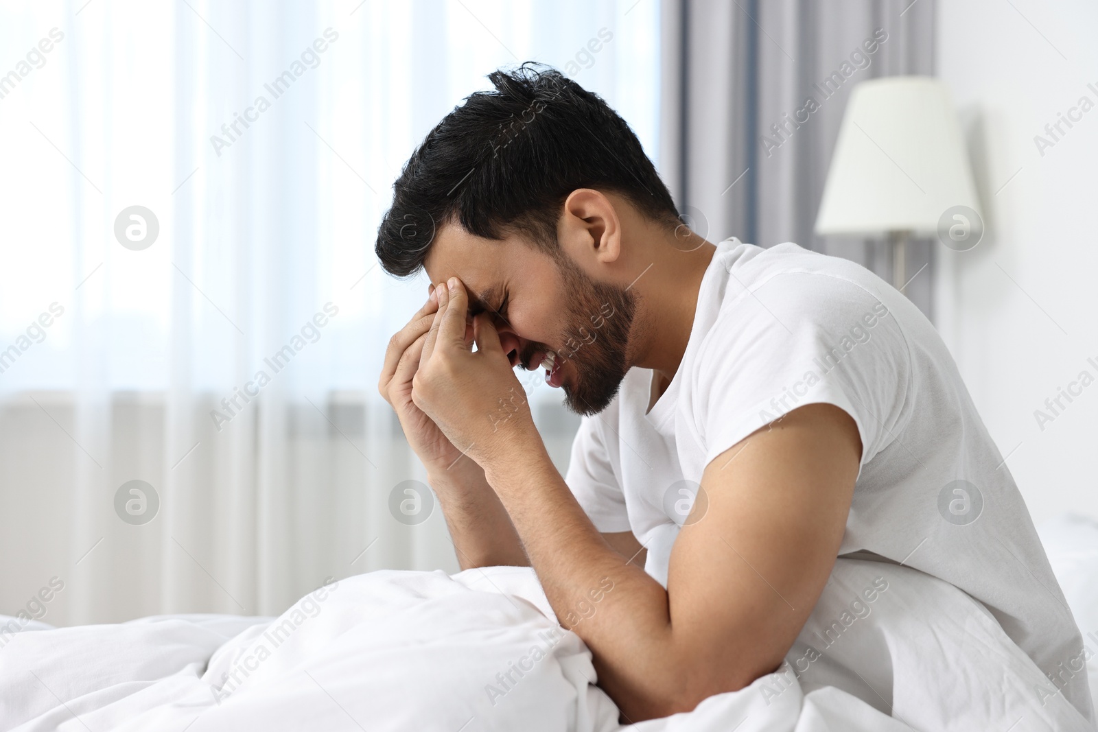 Photo of Morning of man suffering from headache in bed