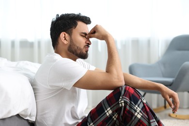 Tired man suffering from headache at morning