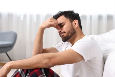 Tired man suffering from headache at morning