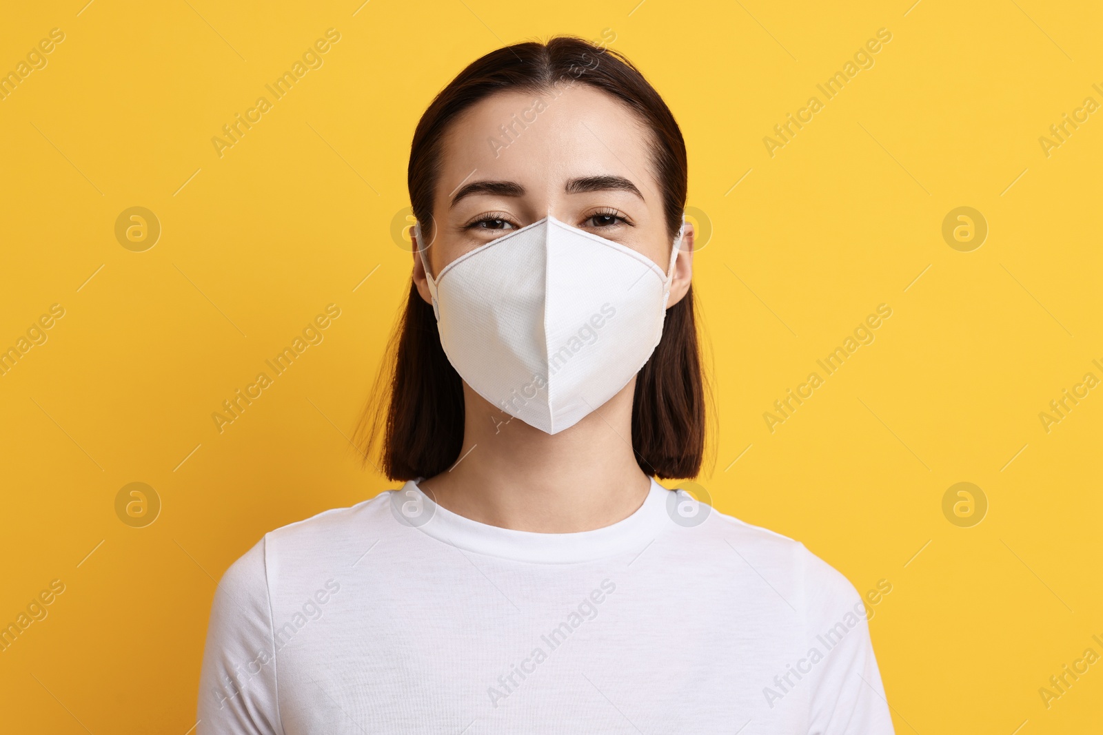 Photo of Woman in respirator mask on orange background