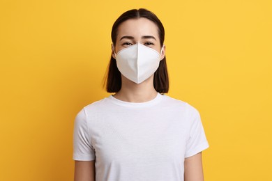 Photo of Woman in respirator mask on orange background
