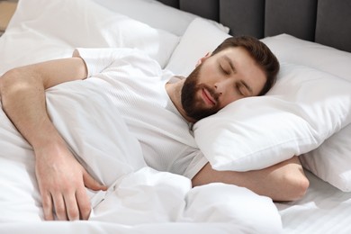 Handsome young man sleeping in bed at morning