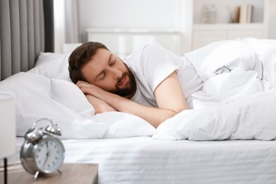 Handsome young man sleeping in bed at morning