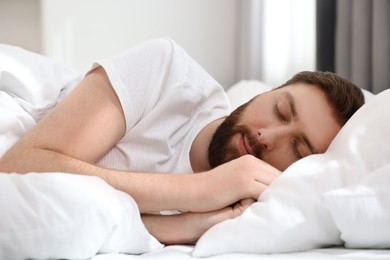 Handsome young man sleeping in bed at morning