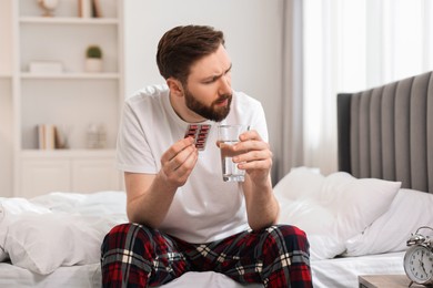 Young man suffering from headache on bed at morning