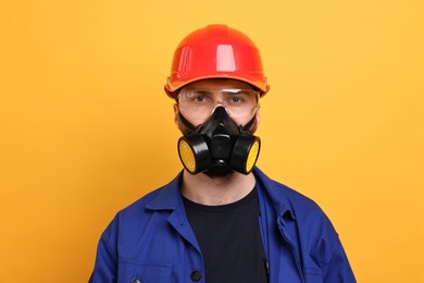 Photo of Man in respirator mask and hard hat on yellow background