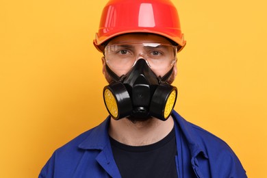 Man in respirator mask and hard hat on yellow background