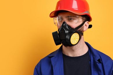 Photo of Man in respirator mask and hard hat on yellow background. Space for text