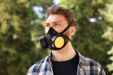 Photo of Man in respirator mask outdoors. Safety equipment