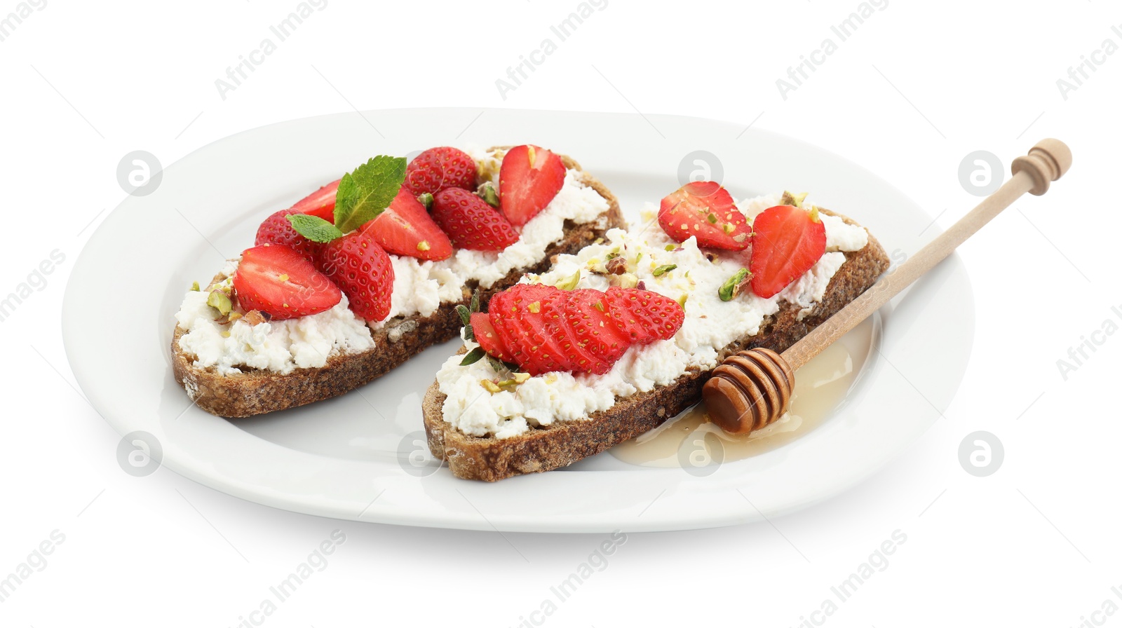 Photo of Delicious ricotta bruschettas with strawberry, mint and pistachios served with honey isolated on white