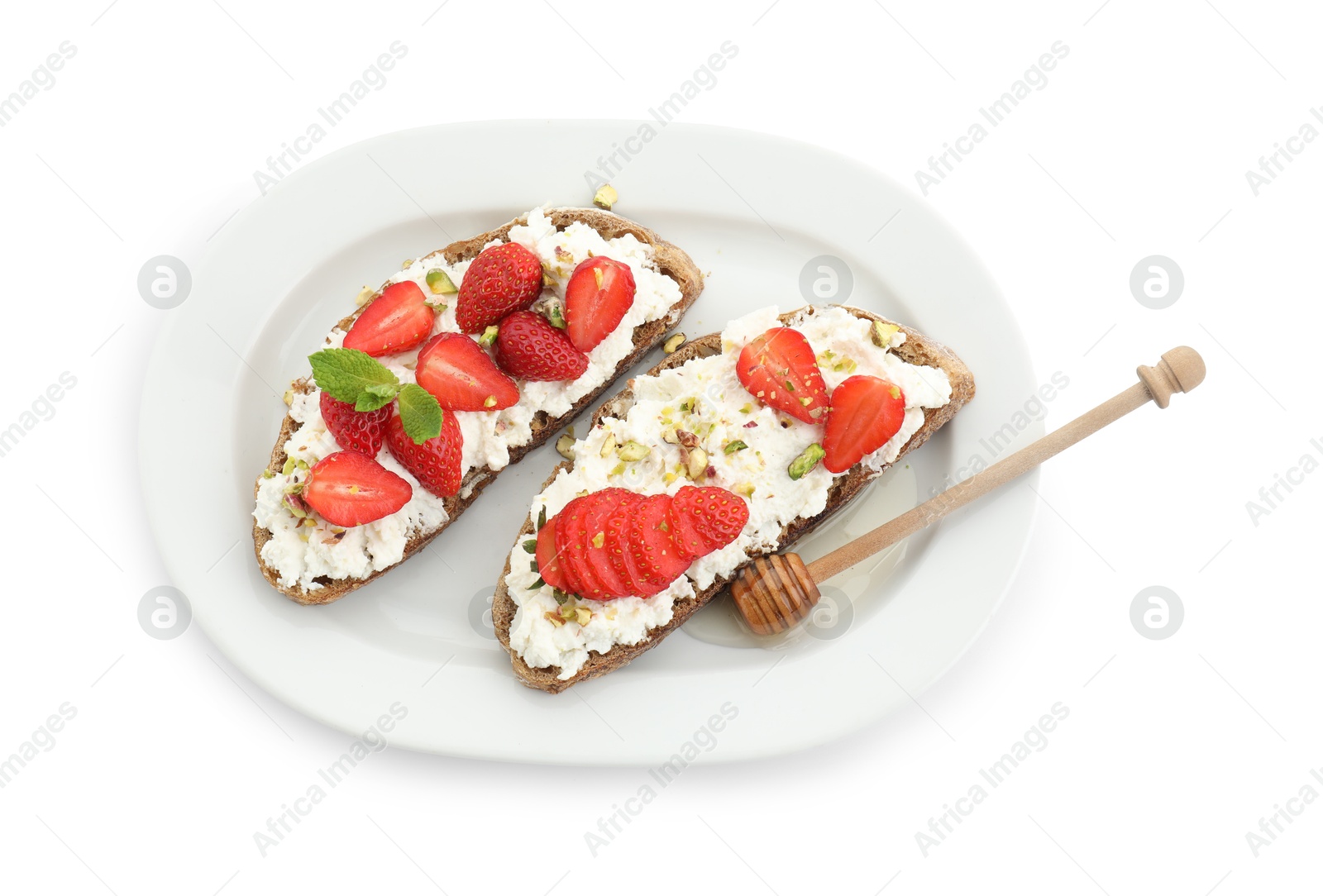 Photo of Delicious ricotta bruschettas with strawberry, mint and pistachios served with honey isolated on white, top view