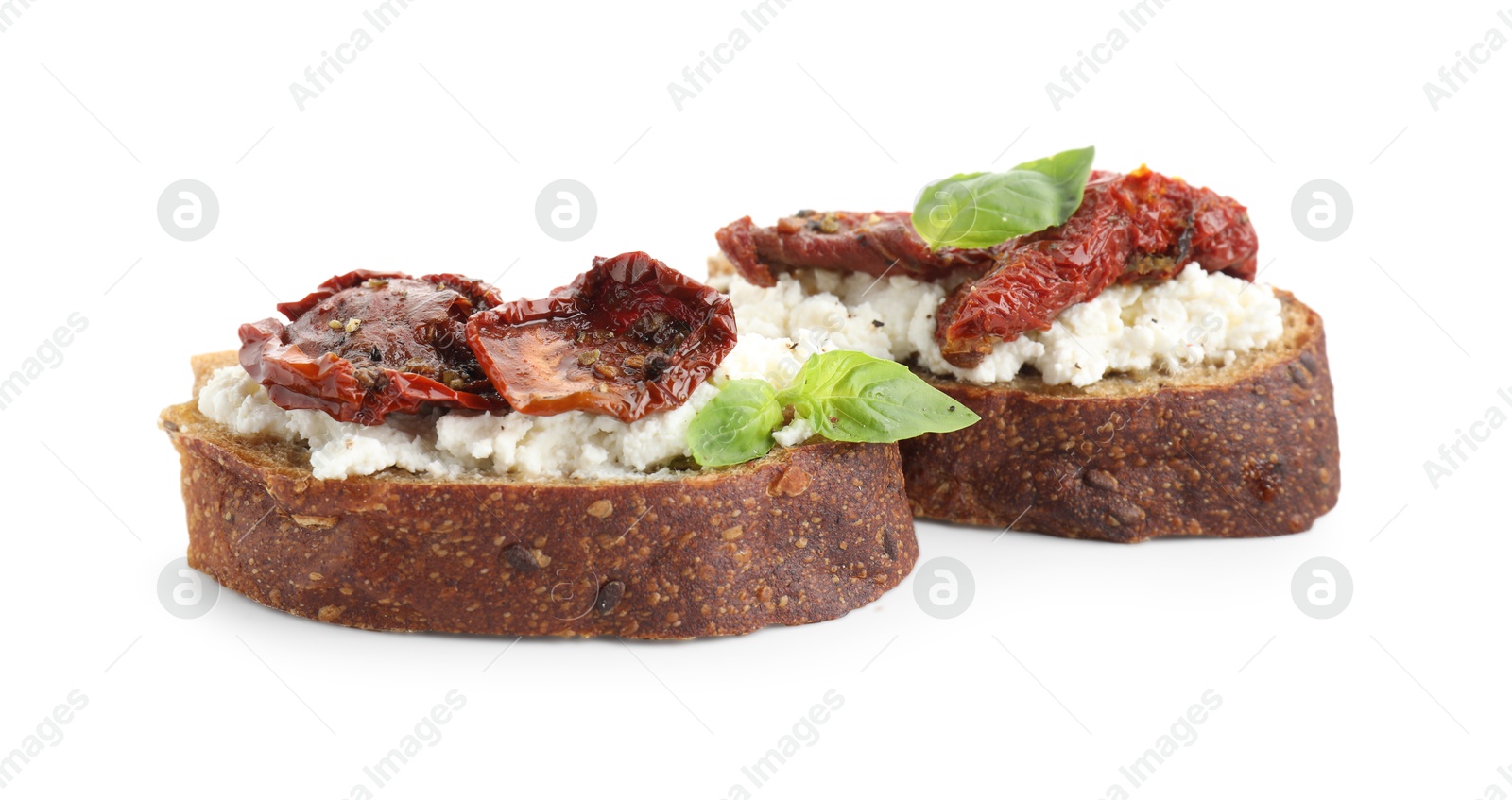 Photo of Delicious ricotta bruschettas with sun dried tomatoes and basil isolated on white